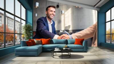 Business people shaking hands during meeting in cafe Wall mural