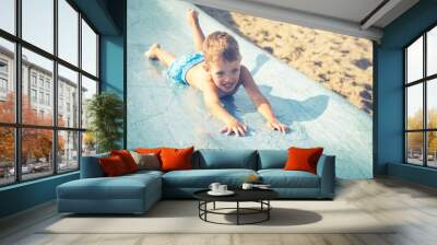 Child on water slide at aquapark, summer holiday Wall mural