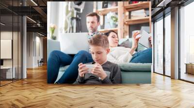 Family with laptop, tablet and smartphone, everyone using digital devices Wall mural