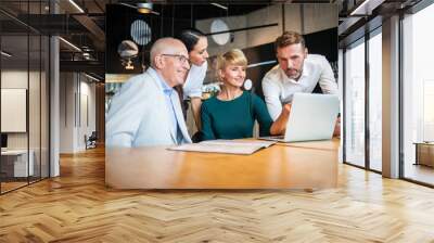 Group of business people with laptop meeting in cafe Wall mural