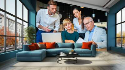 Group of business people with laptop meeting in cafe Wall mural