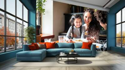 Happy african american family eating lunch together at restaurant and having fun Wall mural