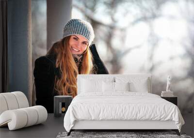 Happy winter time, smiling young woman in the park Wall mural