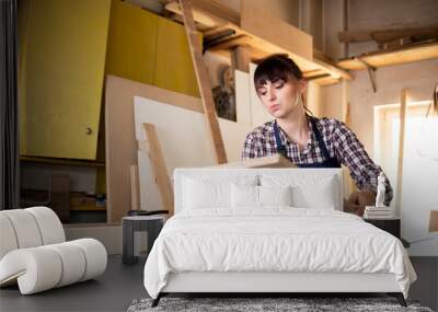 Hardworking woman craftswoman in her carpentry workshop Wall mural