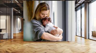 Loving mother hugs her little baby at home Wall mural