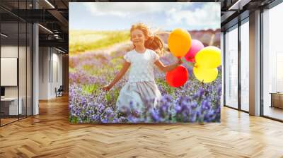 Pretty child girl runs with colorful balloons in lavender field summer freedom concept Wall mural