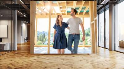 Wife and husband visiting building site of their new house with construction in background Wall mural