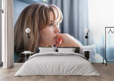 Woman at home deep in thoughts thinking and planning Wall mural