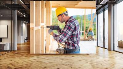 Worker using drill working on construction of wood frame house Wall mural