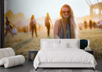 Young beautiful girl during sunset at summer holi festival sitting on grass Wall mural