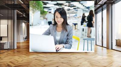 Businesswoman working on notebook computer at co work space Wall mural