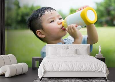 Cute boy drinking water with bottle Wall mural