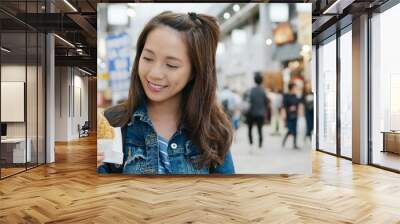 Travel woman eating Taiyaki on the street on Tokyo city Wall mural