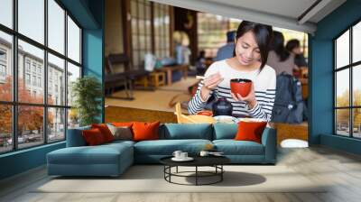 Woman eating in Japanese restaurant Wall mural