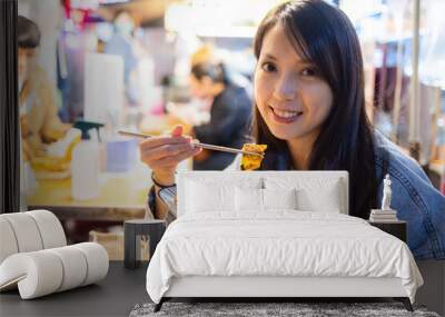 Woman enjoy the pan fried noodles Wall mural