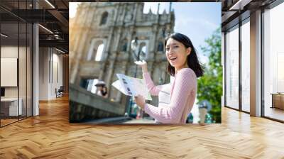 Woman holding city guide in Macao city Wall mural