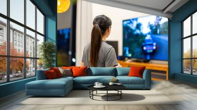 Woman play TV video game at home Wall mural