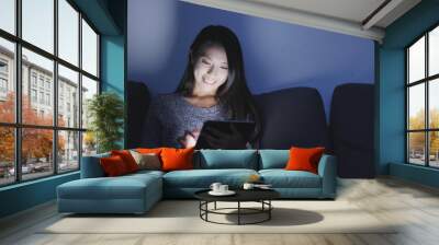 Woman use of tablet computer at night Wall mural