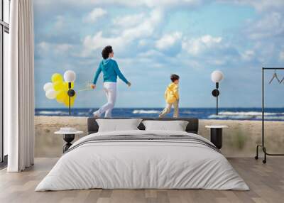 Mother and little son with ballons on the beach Wall mural