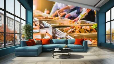 people catering buffet food indoor restaurant on table with drinks, meat, vegetables; blurred background Wall mural