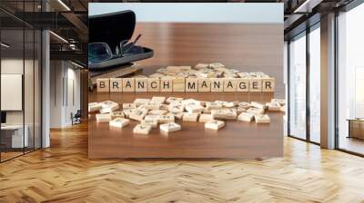 branch manager word or concept represented by wooden letter tiles on a wooden table with glasses and a book Wall mural