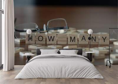 how many word or concept represented by wooden letter tiles on a wooden table with glasses and a book Wall mural