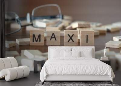 maxi word or concept represented by wooden letter tiles on a wooden table with glasses and a book Wall mural