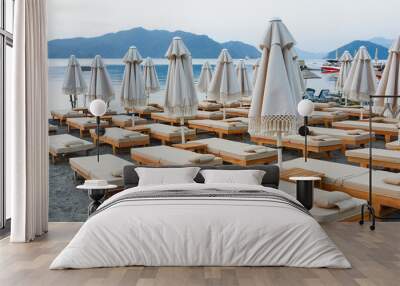 Comfortable sun loungers and umbrellas with cushions on the beach in the bay of Marmaris. Turkey, summer, beach vacation. Wall mural