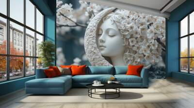 A white ceramic sculpture of a woman's face with a crescent moon behind her, surrounded by white blossoms. Wall mural