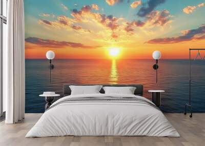 Sunset over the ocean with a golden sky and clouds. Wall mural