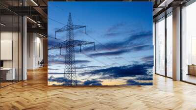 Metal tower and high voltage power lines with sky and clouds at sunset. Province of León, Spain. Wall mural