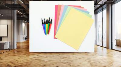 brightly colored paint pens with fanned out multicolored construction paper isolated on white Wall mural