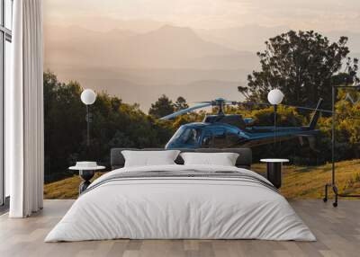 helicopter at sunset with mountains in background Wall mural