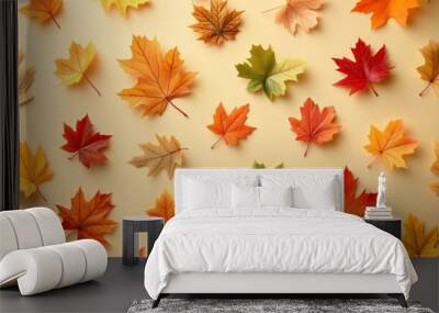 autumn leaves in various colors arranged on a light background, creating a seasonal pattern. Wall mural