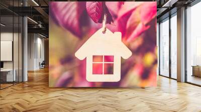 The symbol of the house hangs against the red autumn leaves
 Wall mural