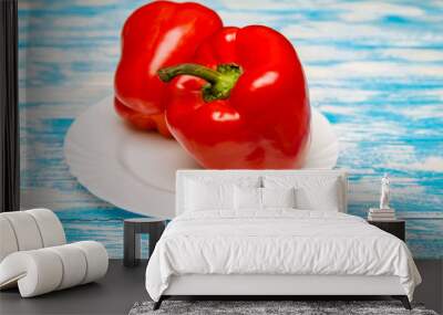 Two red peppers lying on a blue background  Wall mural