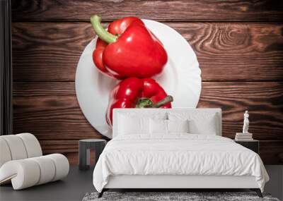 Two red peppers lying on a brown background  Wall mural