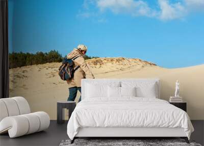 Young woman climbing on the sand dune Wall mural