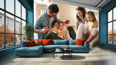 Cheerful family with two child spending time at home. Wall mural