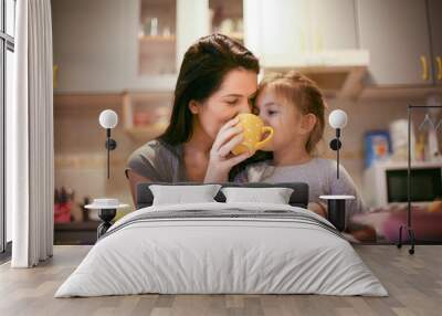 Drinking tea with mom is fun. Little girl. Wall mural