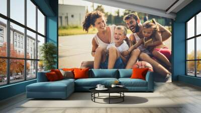 Portrait of family with two children at basketball playground. Wall mural