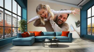 young dad with cute daughter at home. Wall mural