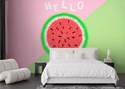 Colourful crochet handmade slice of watermelon on pink and green background. Hello Summer vacation creative tropical bright minimalistic food concept. Flatlay, top view summertime holiday composition Wall mural