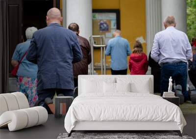 Parishioners of the Catholic Church are on their knees. People on the street pray on their knees Wall mural