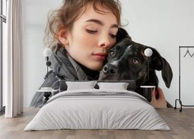 Young woman in cozy attire lovingly embracing her dog in a bright studio Wall mural