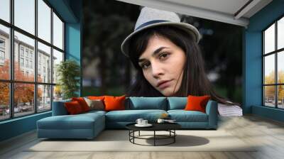 Portrait of a young woman with hat; close up, selective focus background. Wall mural