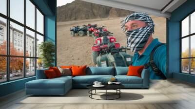 Tourist while riding a quad bike in the Egyptian mountain desert near the resort of Sharm El Sheikh in South Sinai  Wall mural