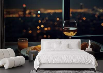 A plate of spaghetti and wine on a table with a view of a city at night in the background Wall mural