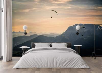 Mesmerizing view of two paragliders flying over the Austrian alps during sunset Wall mural