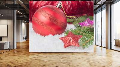 Red Christmas ball with colorful stars on a background of a blurred tinsel Wall mural